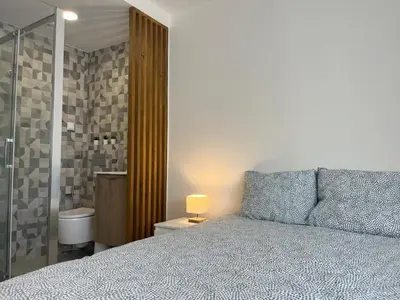 a bedroom with a bed and a lamp on a night stand at Montinho - Apartamento in Faro