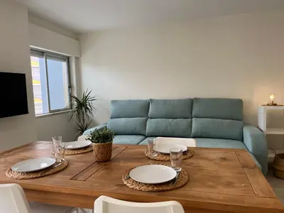a living room with a blue couch and a wooden table at Montinho - Apartamento in Faro