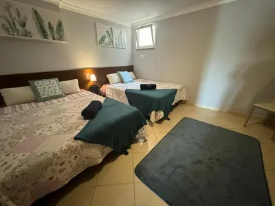 a room with two beds and a table in it at Villa Martin in Albufeira