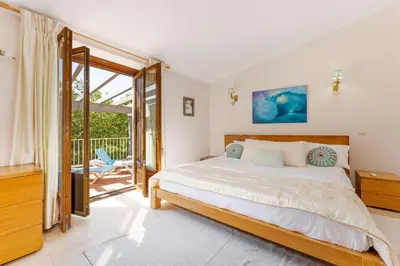 a bedroom with a large bed and a balcony at The Quinta Retreat Algarve Available to Facilitators yoga & sound therapies, massage mindfulness in Almancil