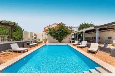 a swimming pool with blue water in a backyard at The Quinta Retreat Algarve Available to Facilitators yoga & sound therapies, massage mindfulness in Almancil
