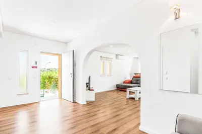 an open living room with white walls and wood floors at Villa Corcovada in Albufeira
