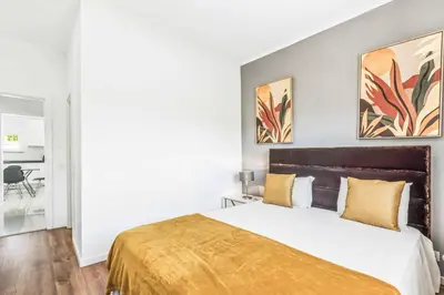a bedroom with a large bed with yellow pillows at Villa Corcovada in Albufeira