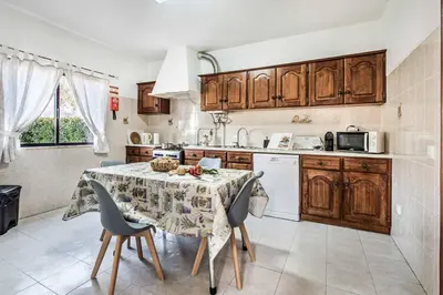 a kitchen with a table and chairs and a kitchen with a sink at Villa Timoneiro in Galé