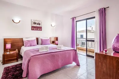 a bedroom with a large bed with a pink blanket at Villa Timoneiro in Galé