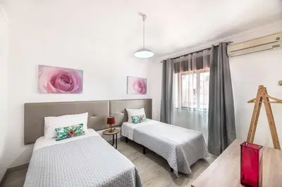a room with two beds and a window at Villa Rosa dos Ventos in Galé