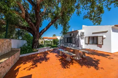 a patio with two benches in front of a house at Villa Rosa dos Ventos in Galé