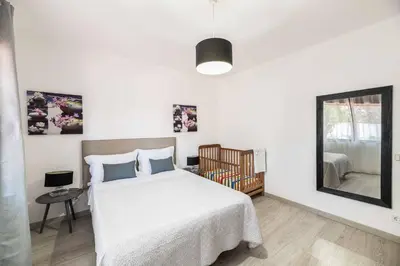 a bedroom with a white bed and a mirror at Villa Rosa dos Ventos in Galé