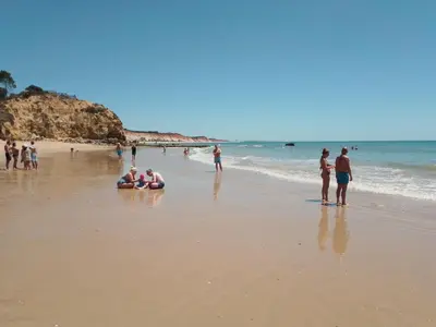 a group of people standing on a beach at BEACH HOUSE in Olhos de Água