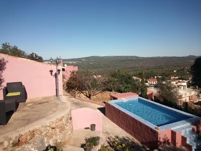 a swimming pool on the side of a house at Bela Vista House - Quinta amoreira in Benafim