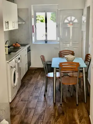a kitchen with a table and chairs in a kitchen at Casa Vitoria - Olhos de Agua - Albufeira in Roja- Pé