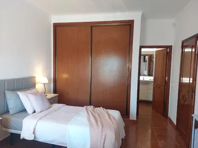 a bedroom with a bed and a wooden closet at Villa Lucia, Olhos D'Agua, Albufeira in Albufeira
