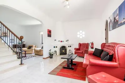 a living room with red furniture and a fireplace at Villa Lucia, Olhos D'Agua, Albufeira in Albufeira