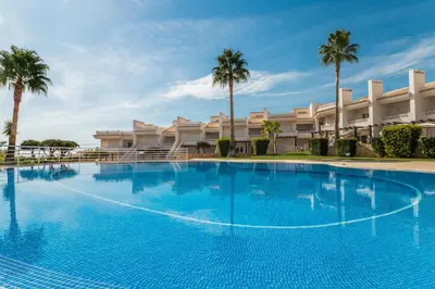 a large blue swimming pool in front of a building at Apartamento albufeira cerro da águia in Albufeira