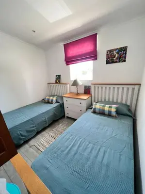 a bedroom with two beds and a desk and a window at Typical quiet Algarve cottage in Faro