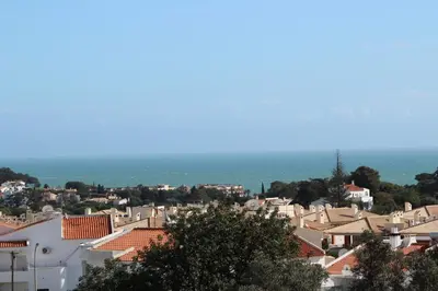 a view of a city with houses and the ocean at Comfy Home in Albufeira