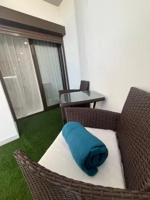 a couch with a blue pillow sitting on a chair at Comfy Home in Albufeira