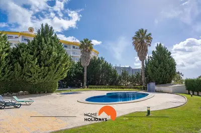 a pool in a park with palm trees and a building at #201 Families Only - Quinta da Flor in Albufeira