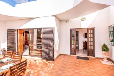 a living room with doors and a table and chairs at Villa Gira in Albufeira