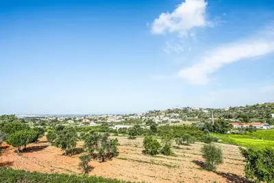 a field with trees and a town in the background at Villa Gira in Albufeira