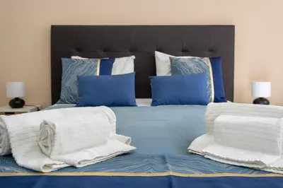 a bed with blue and white pillows and towels at Algarvian Experience - Sun, Beach and Pool in Albufeira
