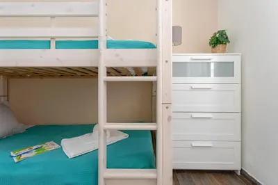 a bunk bed in a room with a ladder and drawers at Algarvian Experience - Sun, Beach and Pool in Albufeira
