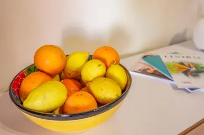 a bowl of lemons oranges and pears on a counter at Avenue Apartment Vilamoura in Quarteira