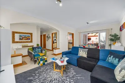 a living room with a blue couch and a table at Avenue Apartment Vilamoura in Quarteira