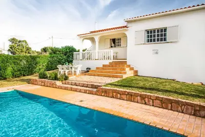 a house with a swimming pool in front of a house at Villa Barrancos in Guia