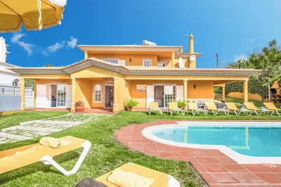 a house with a swimming pool in the yard at Villa Godinho in Albufeira