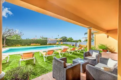 a patio with chairs and a swimming pool at Villa Godinho in Albufeira