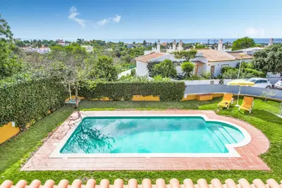 a swimming pool in the yard of a house at Villa Godinho in Albufeira