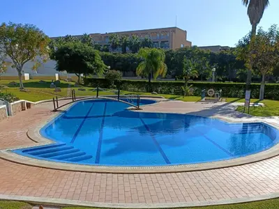 a large swimming pool with two chairs and a table at Casa Estrela do Mar, 2 Quartos, Praia de São Rafael, Albufeira in Albufeira