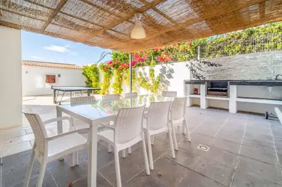 a dining room with a table and chairs on a patio at Villa Catarino in Albufeira