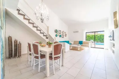 a white dining room with a white table and chairs at Villa Catarino in Albufeira