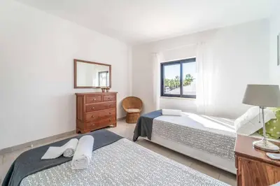 a bedroom with two beds and a window at Villa Catarino in Albufeira