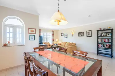 a living room with a dining table and chairs at Villa Gabie in Albufeira