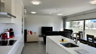 a kitchen and living room with a sink and a couch at Harmony by Check-in Portugal in Albufeira