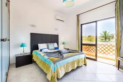 a bedroom with a large bed and a large window at Villa Palmeiras - Serene Private Villa in Albufeira
