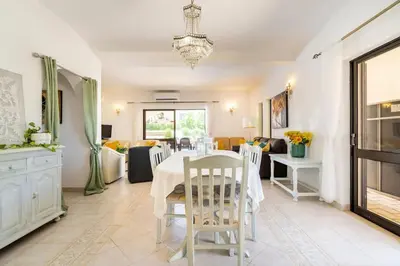 a dining room with a white table and chairs at Villa Palmeiras - Serene Private Villa in Albufeira