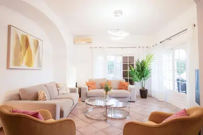 a living room with two couches and a table at Villa Angélica - Cozy Homestay in Albufeira