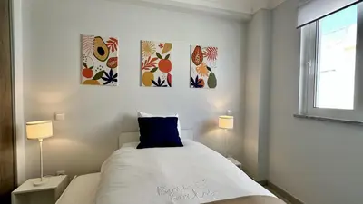 a bedroom with a bed with three paintings on the wall at Hibisco 1 by Check-in Portugal in Albufeira