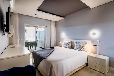 a bedroom with a large bed and a balcony at Varandas do Sol by Garvetur in Vilamoura