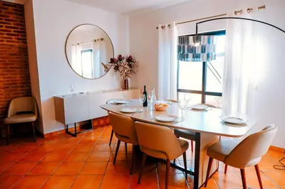 a dining room with a table and chairs and a mirror at Villa Miracampo - Elegant Secret in Albufeira
