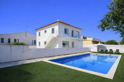 a villa with a swimming pool in front of a house at Hibisco 2 by Check-in Portugal in Albufeira