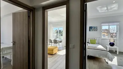a bedroom with a bed and a room with a mirror at Hibisco 2 by Check-in Portugal in Albufeira
