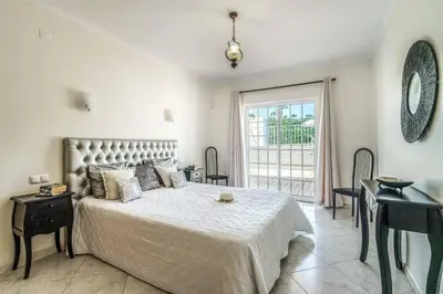 a bedroom with a bed and a desk and a window at Villa Judite in Albufeira