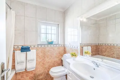 a bathroom with a toilet and a sink and a tub at Villa Judite in Albufeira