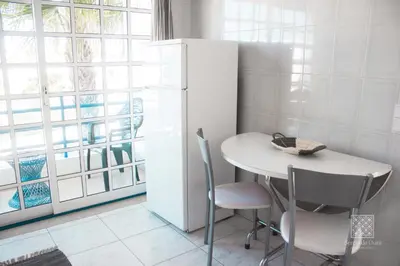 a kitchen with a white table and chairs and a window at Apartamentos Sereia da Oura in Albufeira