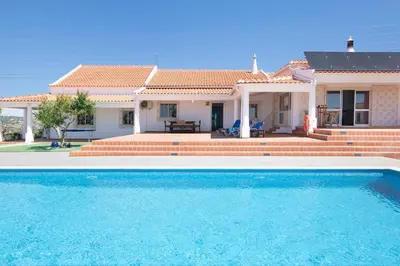 a villa with a swimming pool in front of a house at Monte do Pataco in Albufeira